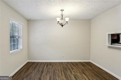 Spare room with a Dining room baseboards, Chandelier, and Luxury Vinyl Floors