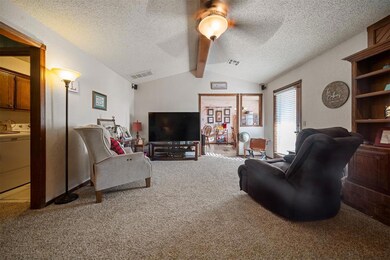 Carpeted living room featuring a textured ceiling,