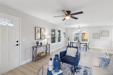 Living area with light wood-style floors and ceiling fan