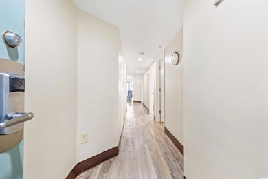 Corridor with light hardwood / wood-style flooring
