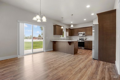 Kitchen with recessed lighting, a breakfast bar, hanging light fixtures, stainless steel appliances, and light wood finished floors