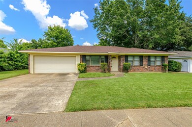 Single story home featuring a garage and a front y
