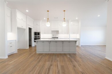 Kitchen with white cabinetry, stainless steel oven