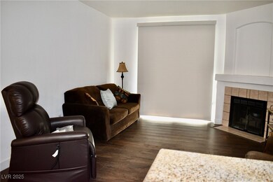 Living room featuring a tiled gas fireplace, wood-