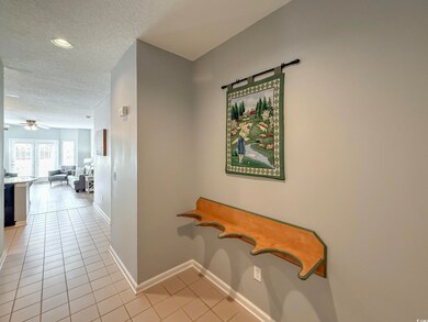 Corridor with a textured ceiling, light tile patte