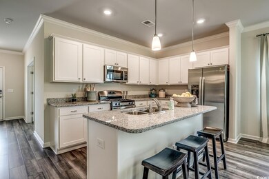 Kitchen featuring stainless steel appliances, a sink, ornamental molding, baseboards, and dark wood-style floors