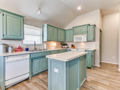 Kitchen featuring white appliances, sink, light ha