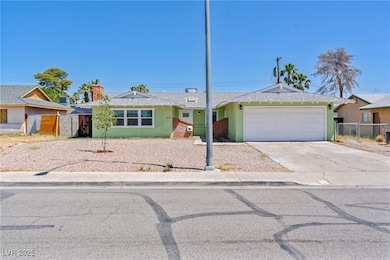 Ranch-style home with a garage, driveway, a chimne