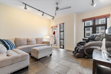 Living room with track lighting, ceiling fan, and