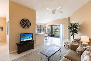 Living area with light tile patterned floors, vaulted ceiling, and ceiling fan