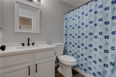 Full bath with  wood finished floors, and curtaine