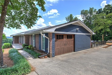View of front of house featuring brick siding and a garage