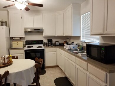 Kitchen with black microwave, electric range oven