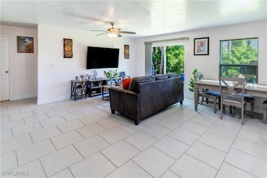 Living room featuring ceiling fan and light tile p