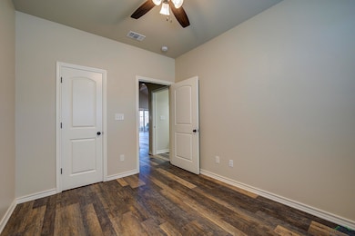 Unfurnished bedroom featuring dark wood-style floo