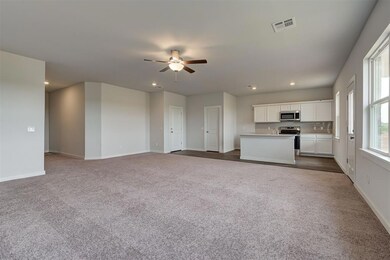 Unfurnished living room featuring dark colored carpet, ceiling fan, baseboards, and recessed lighting