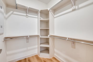 Walk in closet with light wood finished floors