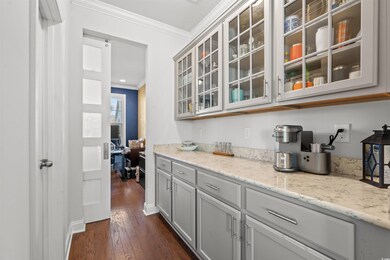 Bar featuring gray cabinetry, light stone counters