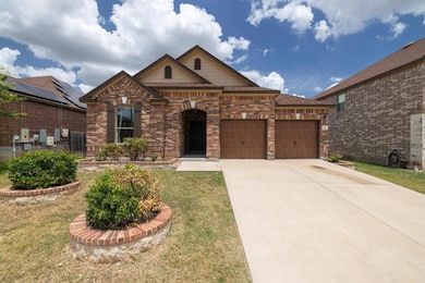 View of front of property featuring a garage, dri