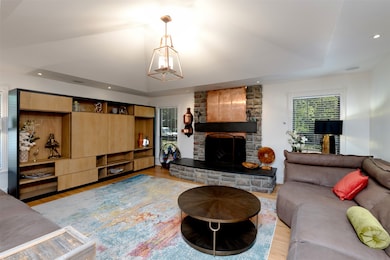 Living area with wood finished floors, a chandelier, a fireplace, and recessed lighting