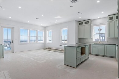 Tall windows flood the living area, adjoining kitc