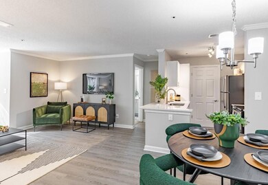 Living room featuring light hardwood / wood-style floors, an inviting chandelier, a textured ceiling, and crown molding