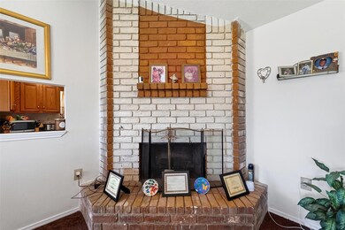 Detailed view of a fireplace, stainless steel microwave, and carpet