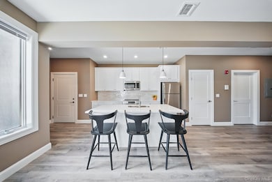 Kitchen featuring plenty of natural light, white cabinetry, backsplash, and recessed lighting