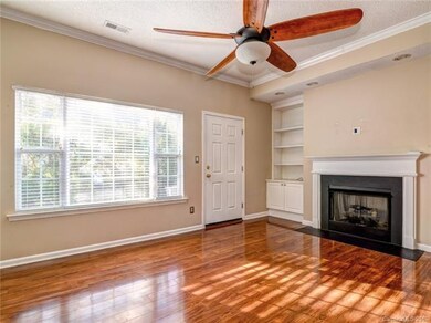 Large Living Room with hardwood floors, gas fireplace, crown molding and built ins with recessed lighting!