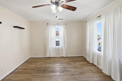 Unfurnished room featuring light wood-style floors, healthy amount of natural light, and a ceiling fan