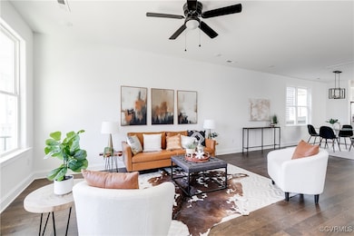 Living room with dark wood-style floors, baseboard