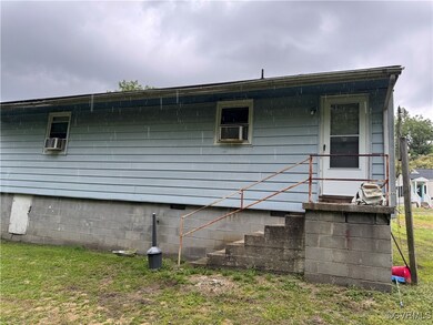 Rear view of house featuring a lawn and crawl spac