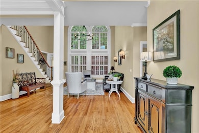 Sunlit entry with soaring ceilings, gleaming hardw