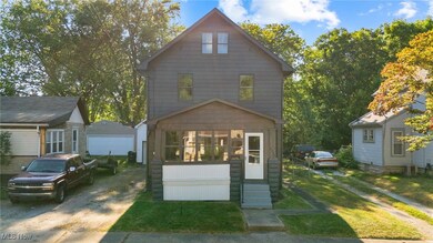 View of front of property featuring an outbuilding, a front lawn, and a detached garage
