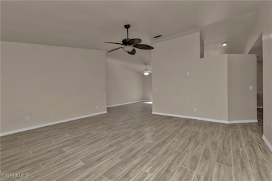 Unfurnished living room with ceiling fan and light