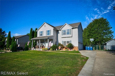 Traditional-style house with covered porch, concrete driveway, brick siding, and a garage