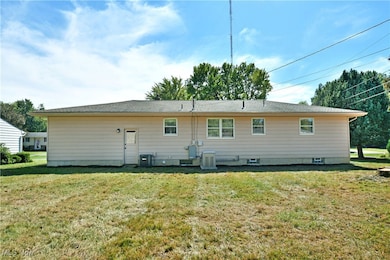 Rear view of house with a yard and a shingled roof