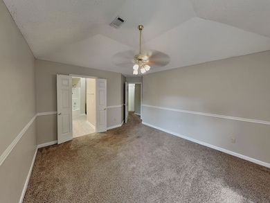 Unfurnished bedroom featuring carpet floors, a textured ceiling, and a ceiling fan