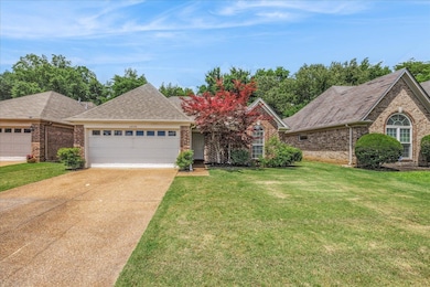 View of front of house featuring brick siding, a garage, and driveway
