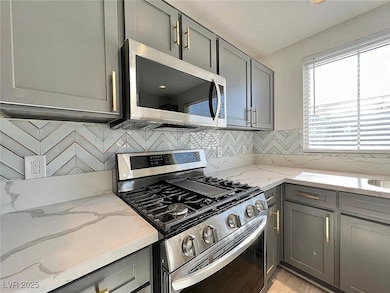 Kitchen featuring gray cabinetry, appliances with