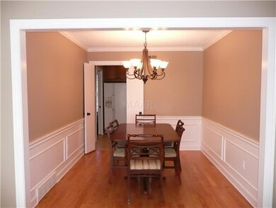 Formal dining room has chair rail design, hardwood