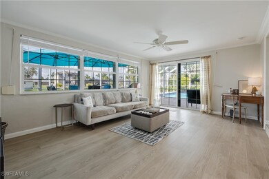 Living room featuring ceiling fan, light hardwood