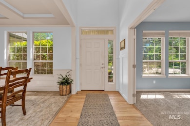 Entryway featuring wood finished floors and crown molding