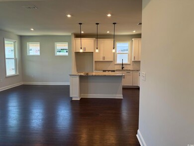 Kitchen featuring white cabinets, decorative backsplash, dark wood finished floors, pendant lighting, and recessed lighting