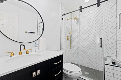 Bathroom with a shower with shower door, vanity, t