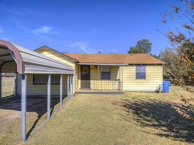 View of front of home featuring a shingled roof and a carport