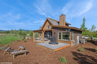 Back of property with a chimney, central AC unit, and a deck with mountain view