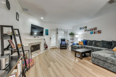 Living room with crown molding, light hardwood / w