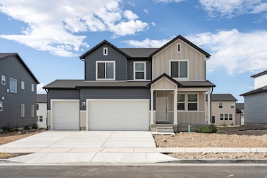 View of front of property with board and batten siding, concrete driveway, covered porch, and a garage