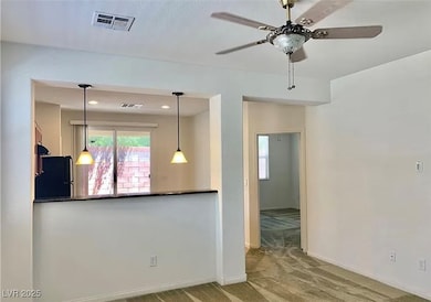 Carpeted empty room with ceiling fan and baseboard